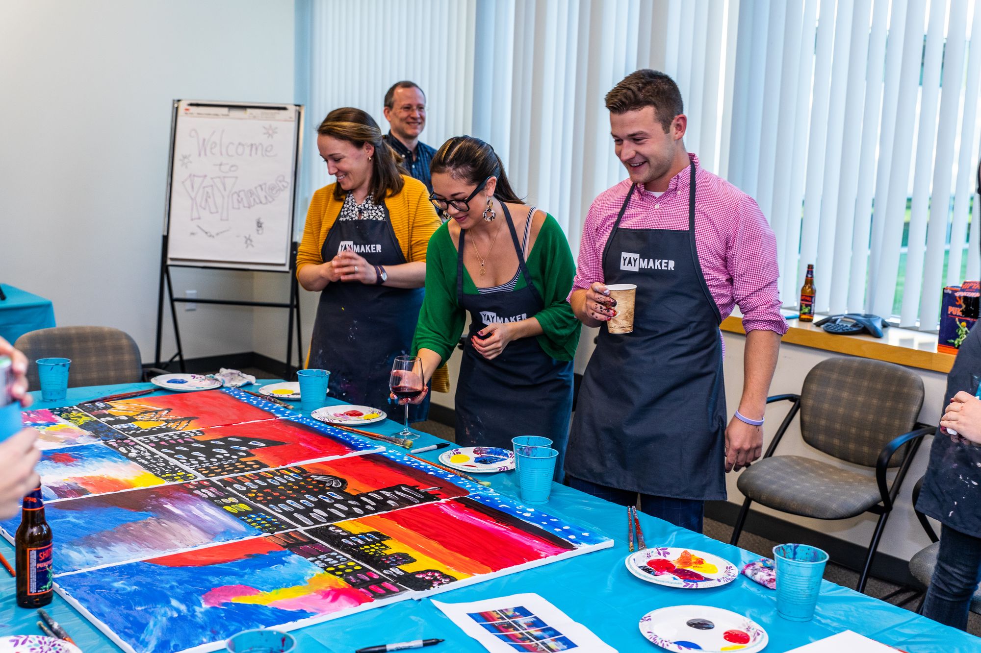 Group working on a collaborative painting at a team building event