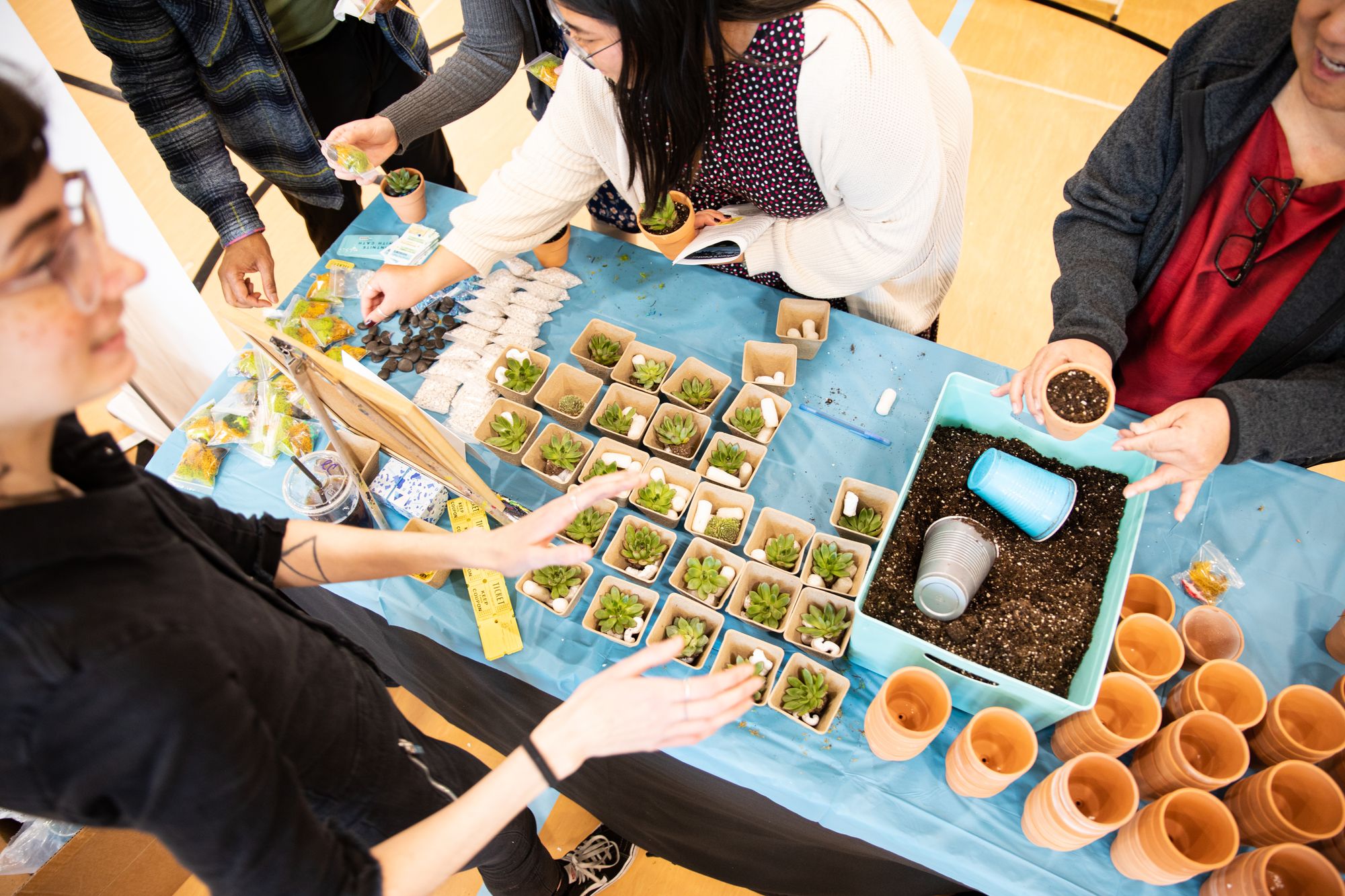 Women creating succulent planters at a Yaymaker-led corporate event