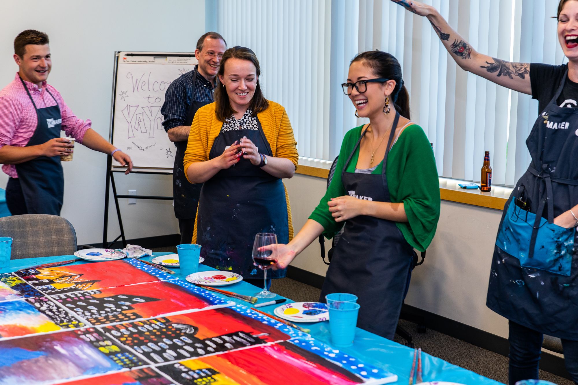 Team members having fun at a paint and sip corporate event.