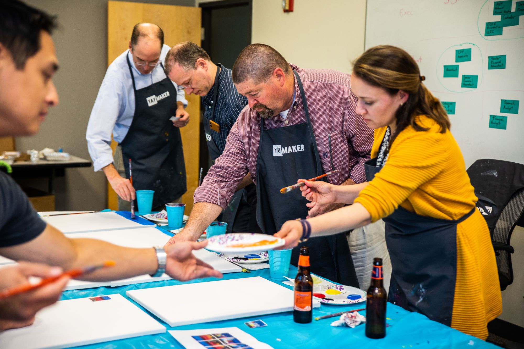 Small group corporate event with Yaymaker where participants are painting.