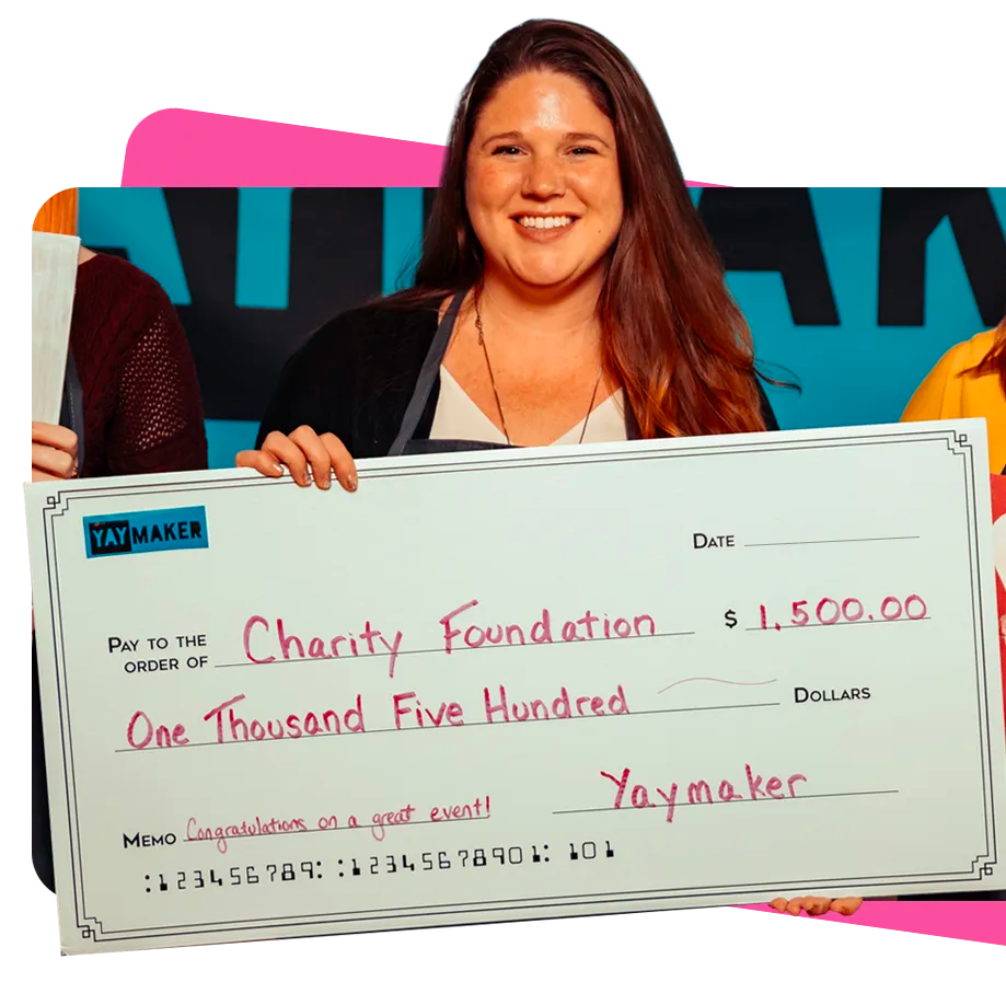 Woman smiling holding giant check after Yaymaker fundraiser