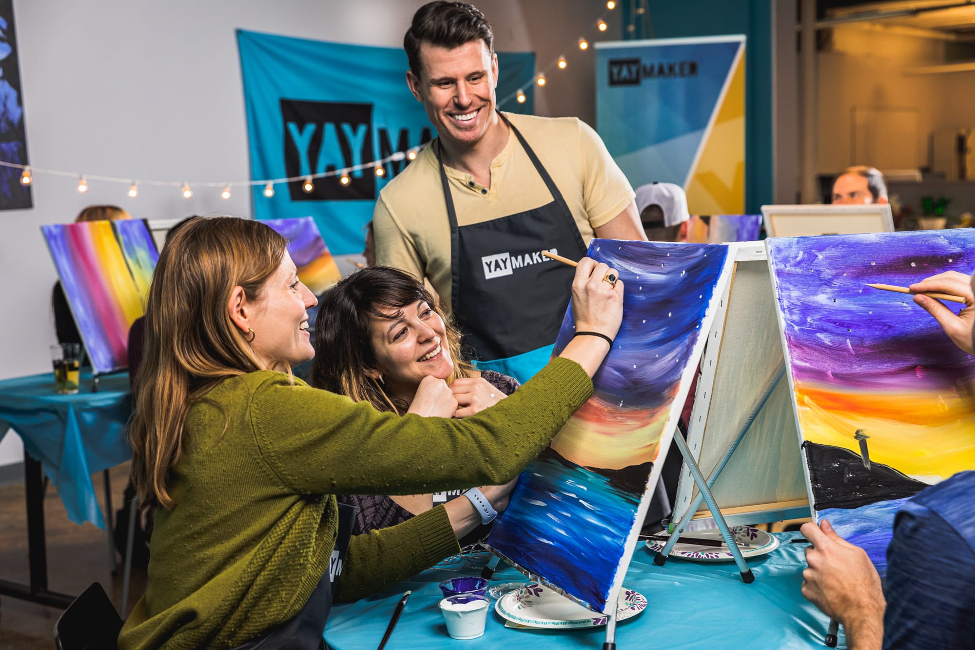 Colleagues painting at Yaymaker Paint Nite event with host